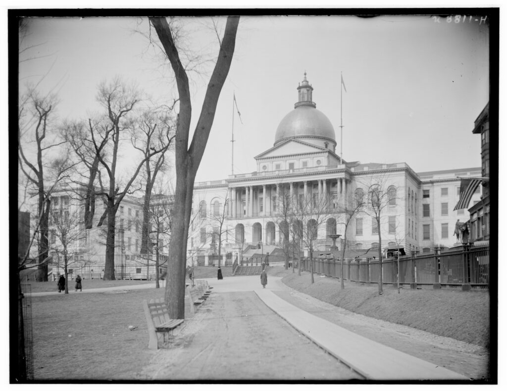 Historic neoclassical building with a grand dome and columns, surrounded by bare trees and a park walkway in the foreground.